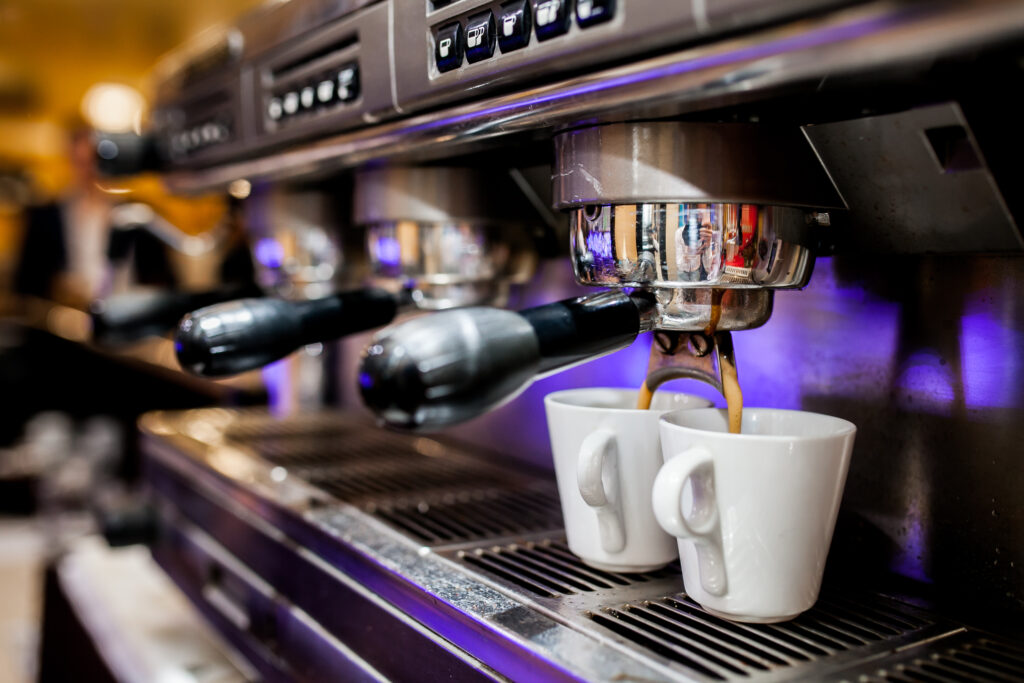 Máquina de café com xícaras em cafeteria, negócio que atua no varejo