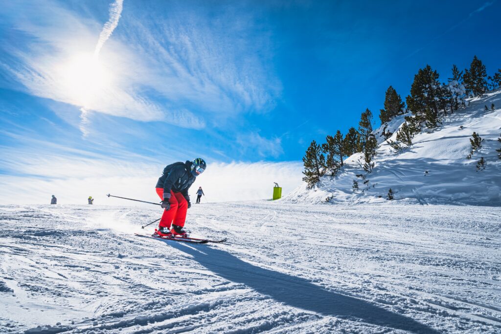 Homem esquiando na neve com céu azul durante a alta temporada