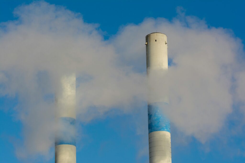 Chaminés de indústria soltando fumaça que intensifica as mudanças climáticas